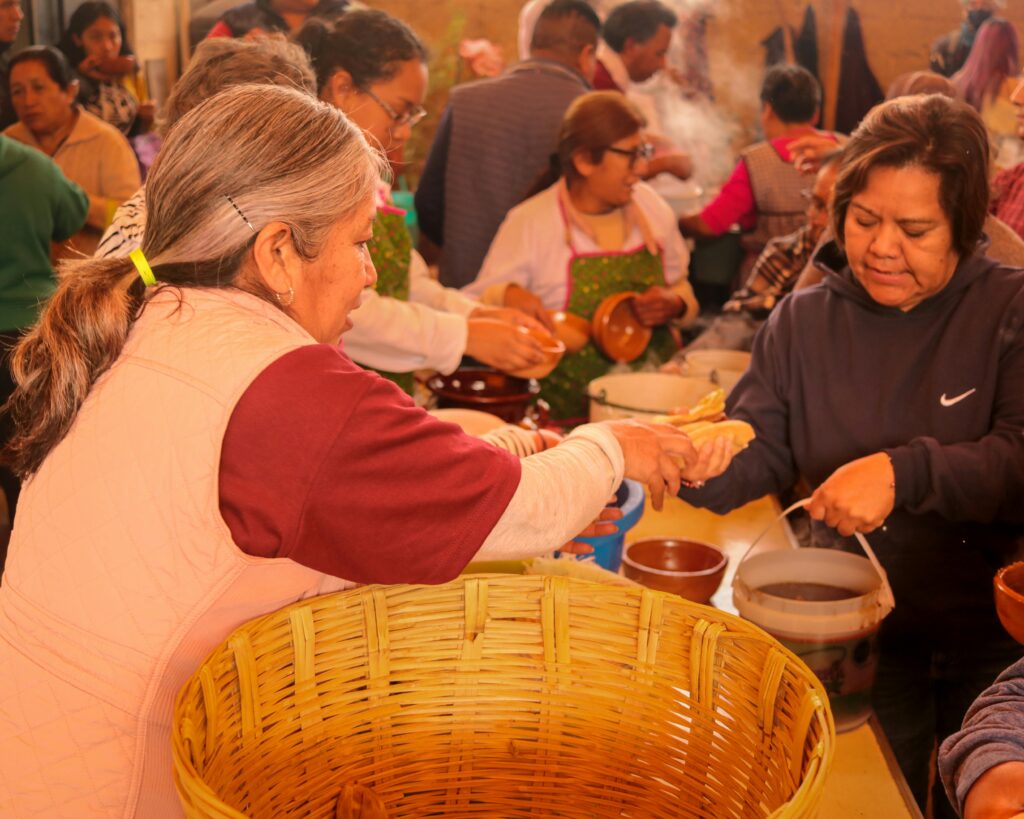 Women distributing food at a community meal in Santa Ana Chiautempan, Mexico.
